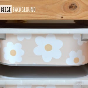 May include: A storage bin with a beige background and white daisy pattern. The bin is inside a wooden shelf. The text "SMALL - BEIGE BACKGROUND" is at the top of the image.