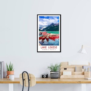 May include: A vintage travel poster featuring a scenic view of Lake Louise in Banff National Park, Canada. The poster depicts a turquoise lake surrounded by mountains, with red canoes docked at the shore. The text "LAKE LOUISE" and "Canadian Rockies" is printed in white on a red background.