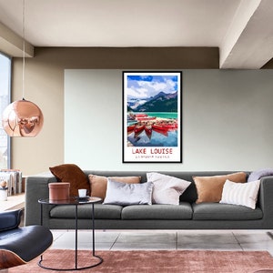May include: A vintage travel poster featuring a scenic view of Lake Louise in Banff National Park, Canada. The poster depicts a turquoise lake with snow-capped mountains in the background and red canoes on the water. The text "LAKE LOUISE" and "BANFF NATIONAL PARK" is printed in white on a black background.