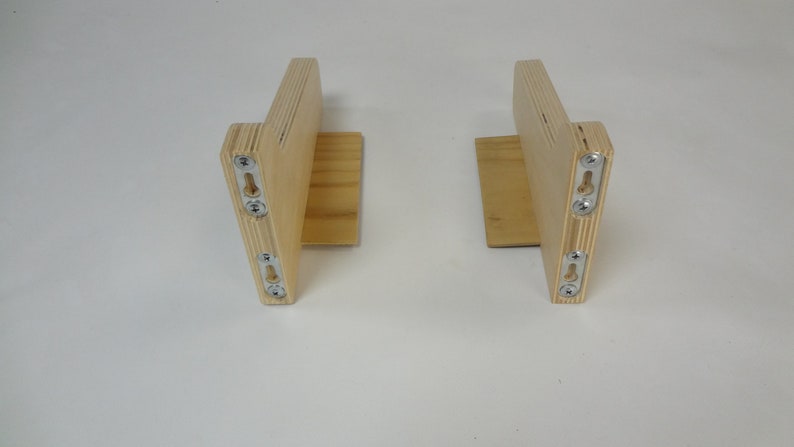 K&ouml;nnte beinhalten: Zwei Holz-Regalbretter mit Metall-Montagehalterungen. Die Halterungen sind aus hellem Holz und haben eine nat&uuml;rliche Oberfl&auml;che.