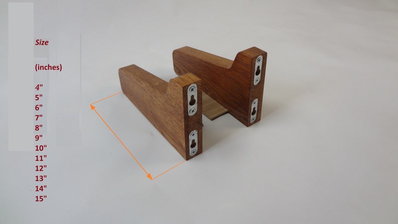 K&ouml;nnte beinhalten: Zwei Holz-Regalhalterungen mit einer dunkelbraunen Beize. Die Halterungen sind 10 cm breit und haben jeweils drei Schraubenl&ouml;cher. Die Halterungen sind aus massivem Holz gefertigt und haben einen rustikalen Look.