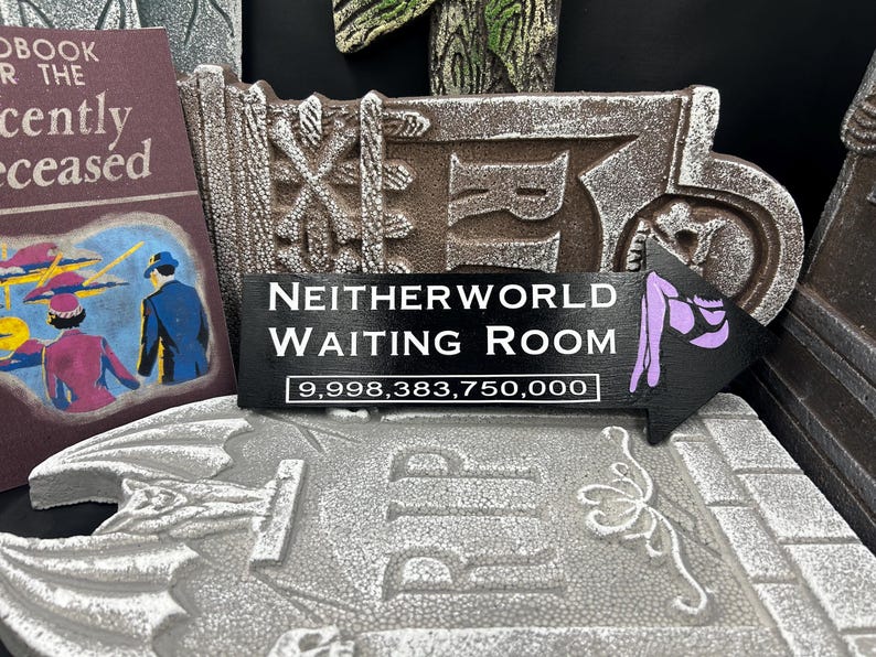 May include: A decorative sign with the text "NEITHERWORLD WAITING ROOM" and an arrow pointing right. The sign is black with white lettering and a purple graphic. The number "9,998,383,750,000" is below the text.