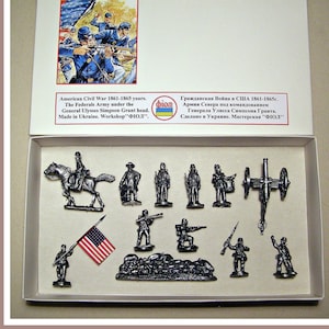 Puede incluir: Un conjunto de 10 figuras de estaño que representan a soldados de la Unión de la Guerra Civil Americana. El conjunto incluye un soldado montado, soldados de infantería, un cañón y una bandera. La caja presenta el texto "American Civil War 1861-1865 years. The Federals Army under the General Ulysses Simpson Grant head. Made in Ukraine. Workshop "ФІОЛ"."