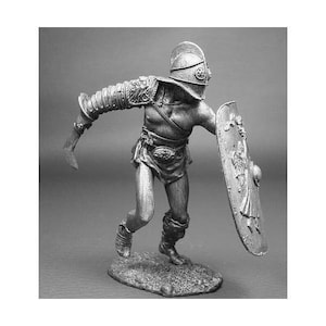 Puede incluir: Una figura de metal plateado de un gladiador romano con casco y armadura, sosteniendo una espada y un escudo. El gladiador corre hacia adelante con la espada en alto.