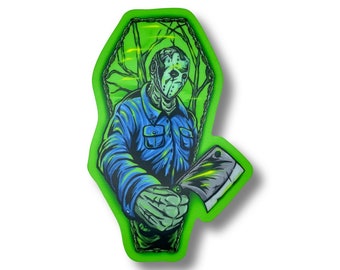 Könnte beinhalten: Grüne und blaue Illustration einer maskierten Figur, die ein großes Messer in einem Sarg-förmigen Rahmen hält. Die Figur trägt ein blaues Hemd und eine weiße Maske mit einem schwarzen Streifen über den Augen. Der Hintergrund ist dunkelgrün mit einem hellgrünen Schein.