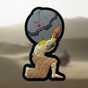 Könnte beinhalten: Ein schwarzer und brauner Patch, der eine knieende Cartoonfigur zeigt, die ein großes, rundes, graues Objekt hebt. Die Figur trägt eine braune Robe und hat einen gelben Körper mit roten Akzenten.