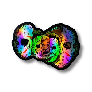 Może przedstawiać: Holograficzna naklejka z czterema maskami postaci z filmów grozy. Maski są w tęczowej kolorystyce i ułożone w kółko. Maski należą do Jasona Voorheesa, Michaela Myersa, Freddy'ego Krugera i Leatherface'a.