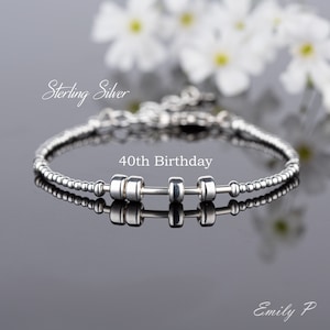 May include: Sterling silver bracelet with a dumbbell charm and the text "40th Birthday".