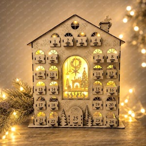 May include: A light-coloured wooden house-shaped advent calendar with twenty-five numbered drawers. The structure features a central illuminated window displaying a festive scene with a star, trees, and stockings, surrounded by small arched windows.