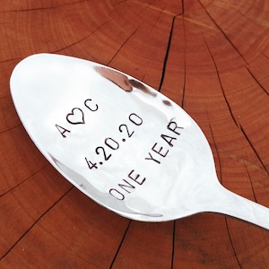 May include: A silver spoon with the inscription "A ♥ C 4.20.20 ONE YEAR" engraved on the front.