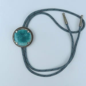 Bolo Tie with Sand Dollar Slider in Shades of Turquoise, Silver Bezel, Grey Cord