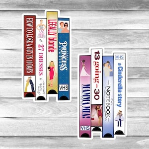 May include: A collection of VHS tape stickers featuring movie titles like "How to Lose a Guy in 10 Days," "27 Dresses," "Legally Blonde," "The Princess Diaries," "Mamma Mia!," "13 Going on 30," "The Notebook," and "A Cinderella Story." Each sticker has a unique color scheme.