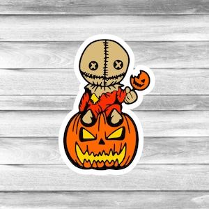 May include: A Halloween-themed sticker featuring a cartoon character with a burlap sack head and stitched details, atop an orange jack-o'-lantern. The character holds a small, bitten pumpkin. The design has a white border.