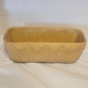 May include: A rectangular, yellow ceramic planter with a textured, diamond-shaped pattern around the rim.