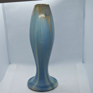Peut inclure: Un vase en céramique bleu et or avec un corps haut et mince et une base évasée.