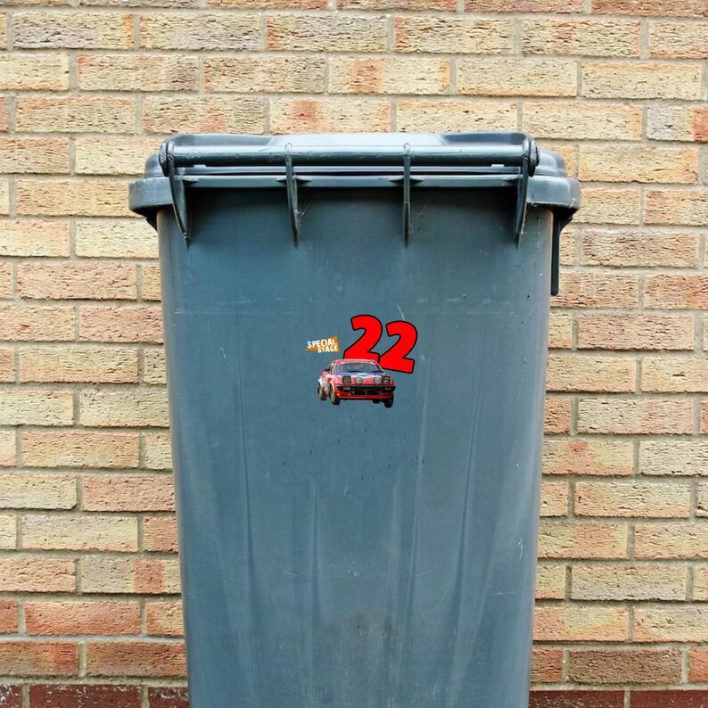 May include: A gray plastic trash can with a red and white sticker that says "Special Stage 22" and a red cartoon car on it.