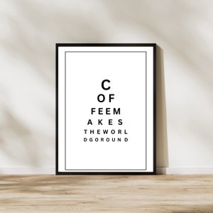 May include: Black and white eye chart print with the text "C of Feem Akes The Worl Dgoround" in a black frame.
