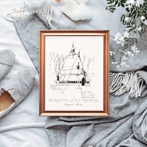 Puede incluir: Un dibujo en blanco y negro enmarcado de la Iglesia de madera de Borgund en Noruega. El dibujo está en un marco dorado y está sobre una manta gris.