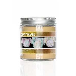 May include: A glass jar candle with a silver lid. The label is gold with the text "DIRTY DIAPER" and an image of three colorful diapers. The text "Made with a vegetable soy wax blend & essential oils" is also on the label.