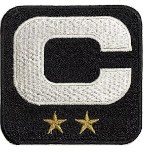 May include: Embroidered patch in black and white, featuring a large white letter "C" with a black centre. Two gold stars are below the letter. The patch is square with rounded corners.