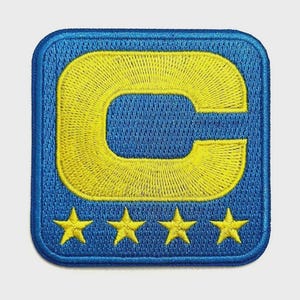 May include: Embroidered patch featuring a large yellow "C" within a blue square. The patch has four yellow stars at the bottom. The design is stitched with a textured appearance, giving it a detailed and high-quality look.