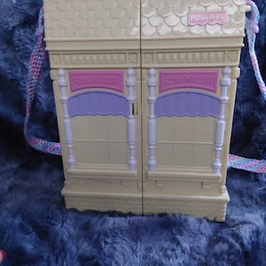 Vintage mini fisher price doll house. This house comes with people and some furniture. The house opens at the front opens up to dif rooms.