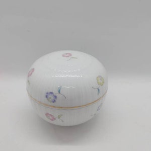 Vintage trinket box a pretty white trinket box with cute colored flowers. The whole trinket box is round, the top opens. Made in Japan.