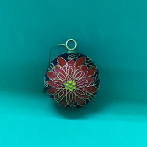 Cuisinay Christmas decoration. A Poinsettia on both sides of this decoration.The pointsetta and the design around this ball are cosinee.
