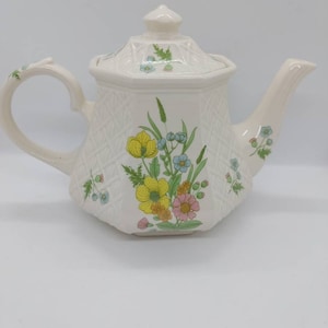 Vintage Sadler teapot with four cups. A matching set in perfect condition. No crazing. Looks brand new. Sadler on the bottom of cups, teapot