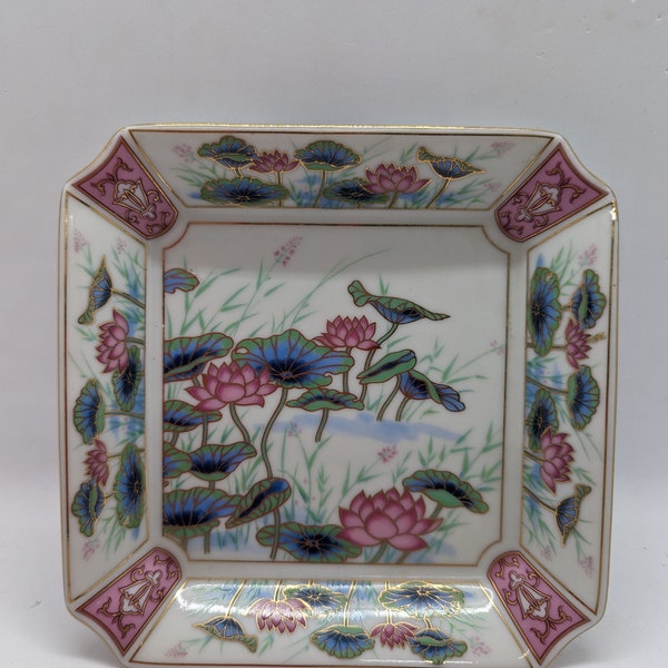 Trinket dish. It is vintage made in Japan. And like brand new condition. The flowers are pond Lily's. Gold trim.