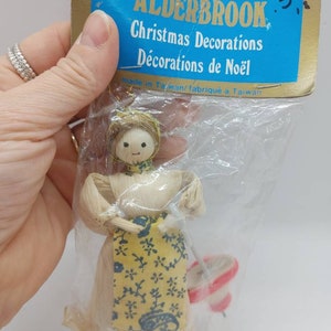 Corn husk dolls still in their package. In brand new condition made in the 1950s. This one has a cute little umbrella.