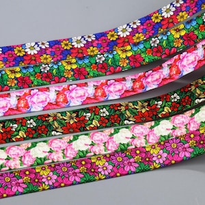 May include: Five different floral patterned ribbons with a variety of colours, including pink, red, green, yellow, and blue.