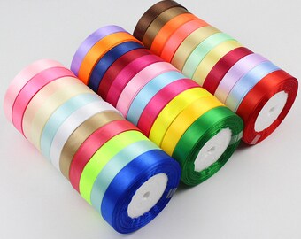 May include: A collection of 1.5 cm wide satin ribbon spools in various colors, including pink, yellow, green, blue, and red.