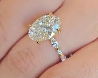 May include: A gold engagement ring with a large oval-shaped diamond and a diamond-encrusted band.