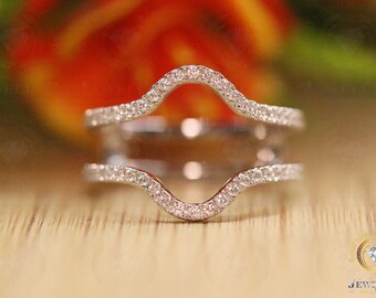 Puede incluir: Un delicado engaste de anillo de doble garra con un diseño ondulado. El engaste es de plata y presenta pequeñas piedras preciosas transparentes.