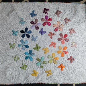 Hand made nursery quilt, applique flowers and butterflies in rainbow colours. Free motion quilted