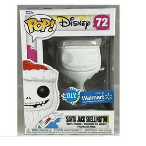 May include: A white, unpainted, plastic figurine of Santa Jack Skellington from the Nightmare Before Christmas movie. The figurine is in a clear plastic box with a colorful background. The box has the words "Pop! Disney" and "DIY Walmart" on it.