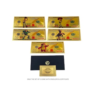 K&ouml;nnte beinhalten: Satz von f&uuml;nf goldfarbenen Toy Story-Motiven im Wert von 100 $ mit Woody, Buzz Lightyear, Jessie, Rex und Bullseye. Die Scheine werden mit einem schwarzen Umschlag und einem goldfarbenen Zertifikat geliefert.