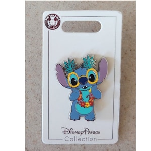 May include: Blue Stitch character wearing yellow sunglasses and a flower lei. The pin is on a white card with the text "Disney Parks Collection".