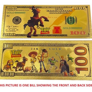 K&ouml;nnte beinhalten: Ein goldfarbener Papier-Geldschein mit Toy Story-Motiv. Die Vorderseite zeigt Woody, die R&uuml;ckseite die gesamte Toy Story-Bande. Der Schein tr&auml;gt die Aufschrift "24K Gold" und "One Hundred Dollars".