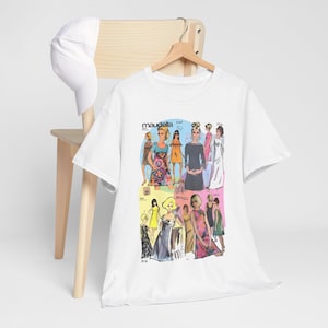 May include: A white short-sleeved t-shirt featuring a colorful graphic print of vintage Maudella sewing pattern illustrations. The design displays various figures in dresses against pastel backgrounds. A plain white baseball cap is also visible.