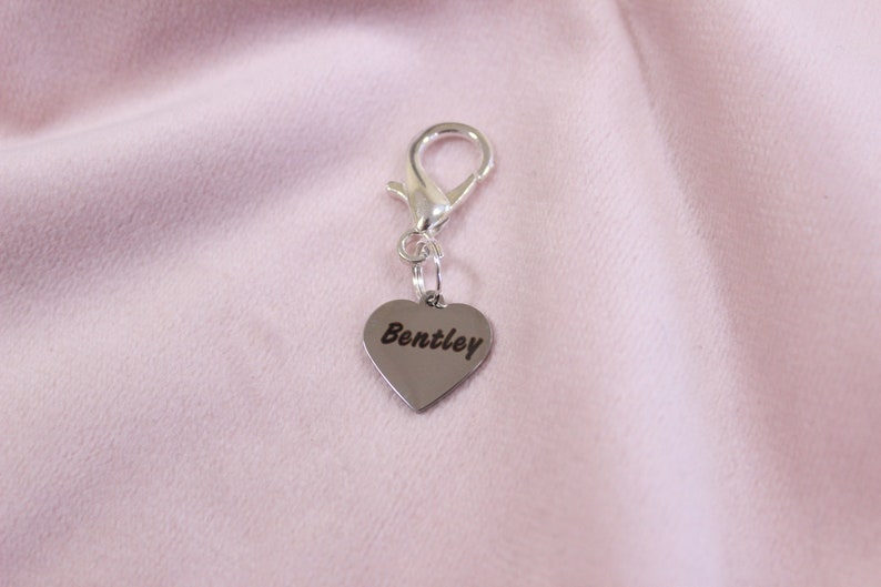 Bright silver engraved heart charm on dark bridle strap, featuring custom text for horse tack personalization.