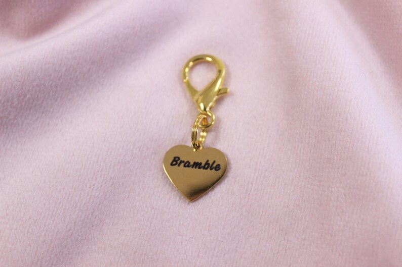 Detailed close-up of engraved horse name on polished heart charm, designed as a personalized bridle accessory.