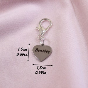 May include: A silver-toned heart-shaped charm with a lobster clasp, featuring the engraved name Bentley. The charm measures 0.59 inches in height and 0.59 inches in width, as indicated by the text and arrows visible in the image.