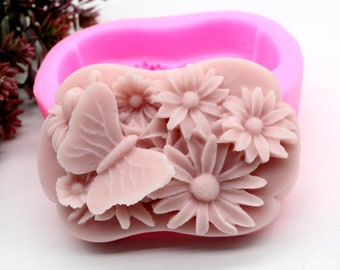 May include: Pink silicone mold for making soap or resin crafts. The mold features a detailed design of a butterfly and flowers.