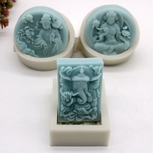 Puede incluir: Tres moldes de silicona para hacer jabón o velas. Los moldes son de forma circular y rectangular. Los moldes circulares presentan un diseño azul y blanco de una deidad. El molde rectangular presenta un diseño azul y blanco de una deidad elefante.