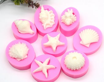May include: Pink silicone mold with eight different shapes of seashells and starfish. The mold is designed to create edible decorations for cakes and other desserts.