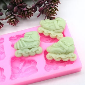 Könnte beinhalten: Rosa Silikonform mit sechs Vertiefungen in Form von Rollschuhen. Die Form ist mit grünen Rollschuhformen gefüllt.