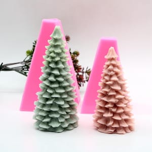Puede incluir: Dos moldes de silicona rosa para hacer velas de árbol de Navidad. Los moldes tienen forma de triángulo y tienen un diseño detallado de un árbol de Navidad.