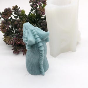 以下が含まれることがあります： ろうそくや石鹸を作るための青いドラゴン型のシリコンモールド。モールドは、鱗ととげのある背中で詳細に作られています。